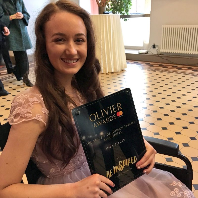 pippa in formal wear sat in wheelchair holding olivier awards be inspired plaque