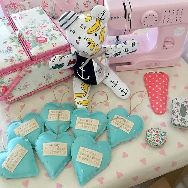hand sewn teddy and heart decorations with pink sewing machine displayed in background