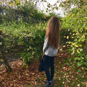 pippa stood outdoors with back to camera, displaying long brunette hair