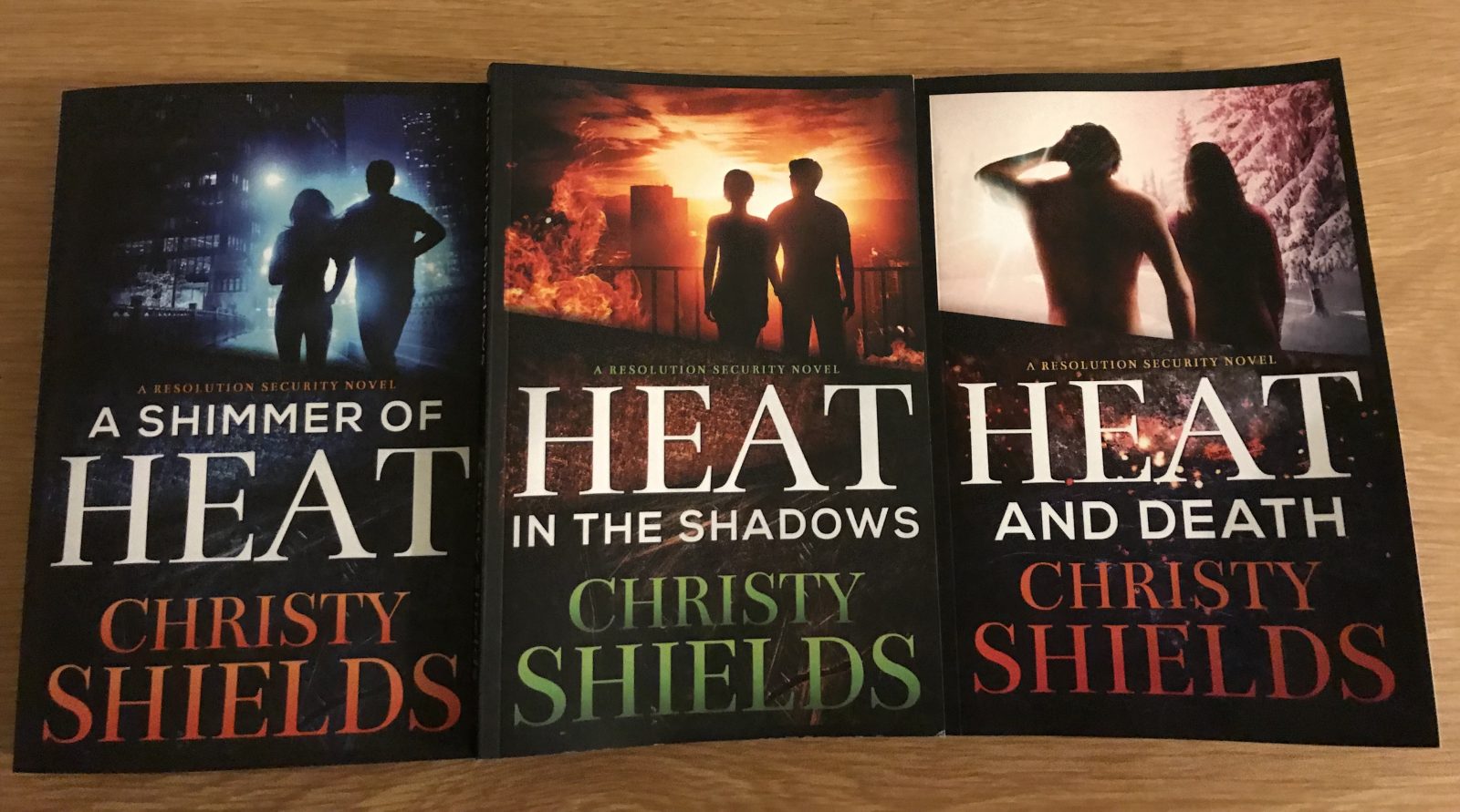 three shimmer of heat novels placed next to each other on a table