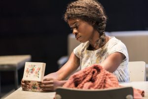 faith omole as joy, sat at table looking down into a musical box