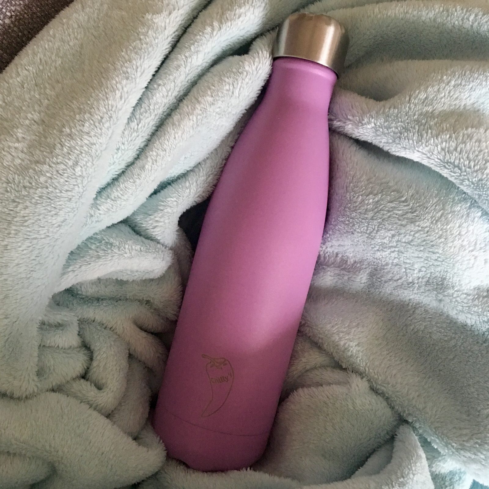 lilac chills water bottle places on blue blanket