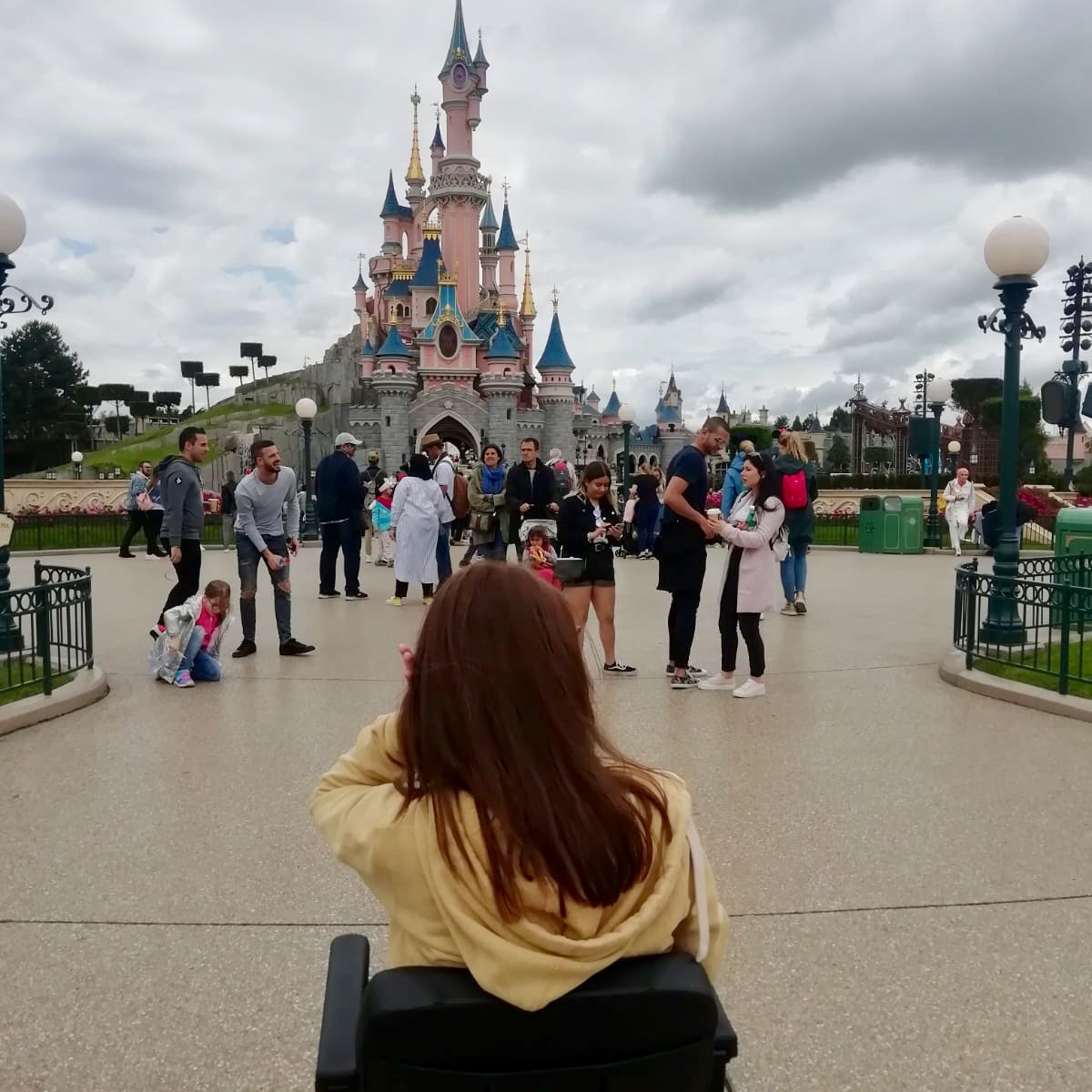 pippa in powerchair with back to camera, disneyland paris castle in background