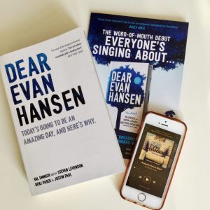 flatlay of dear evan hansen novel, promotional leaflet, and phone showing dear evan hansen cast recording playing