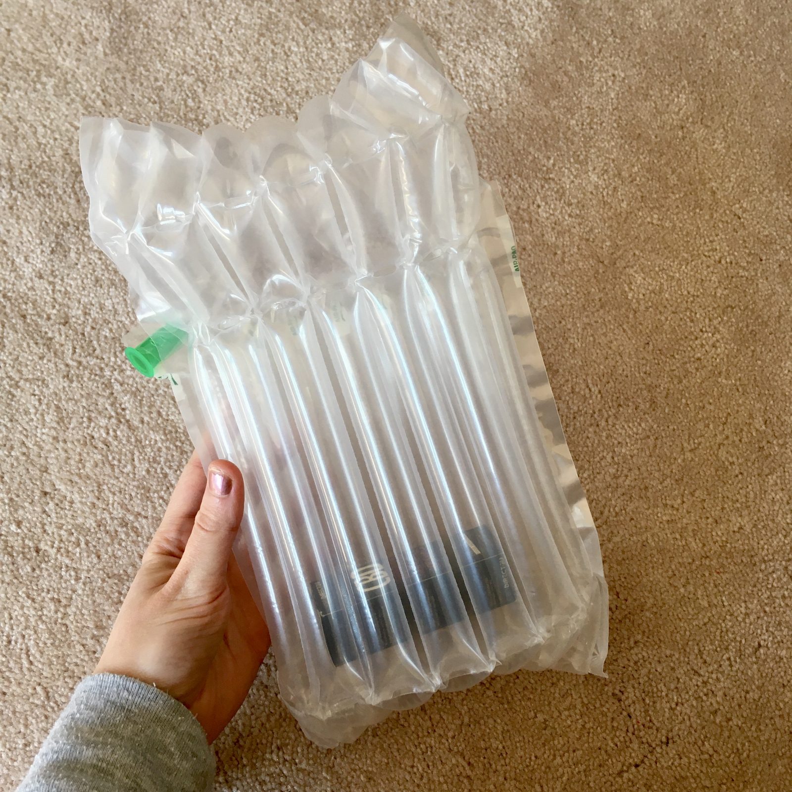 pippa's hand holding inflated protective see-through bag, with CBD oil enclosed