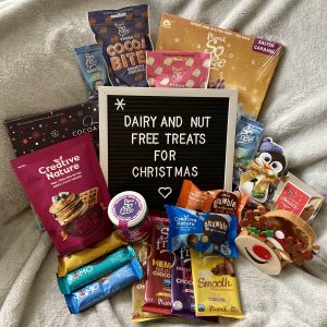 collection of free-from treats arranged on sofa, surrounding a letterboard reading 'dairy and nut free treats for christmas'