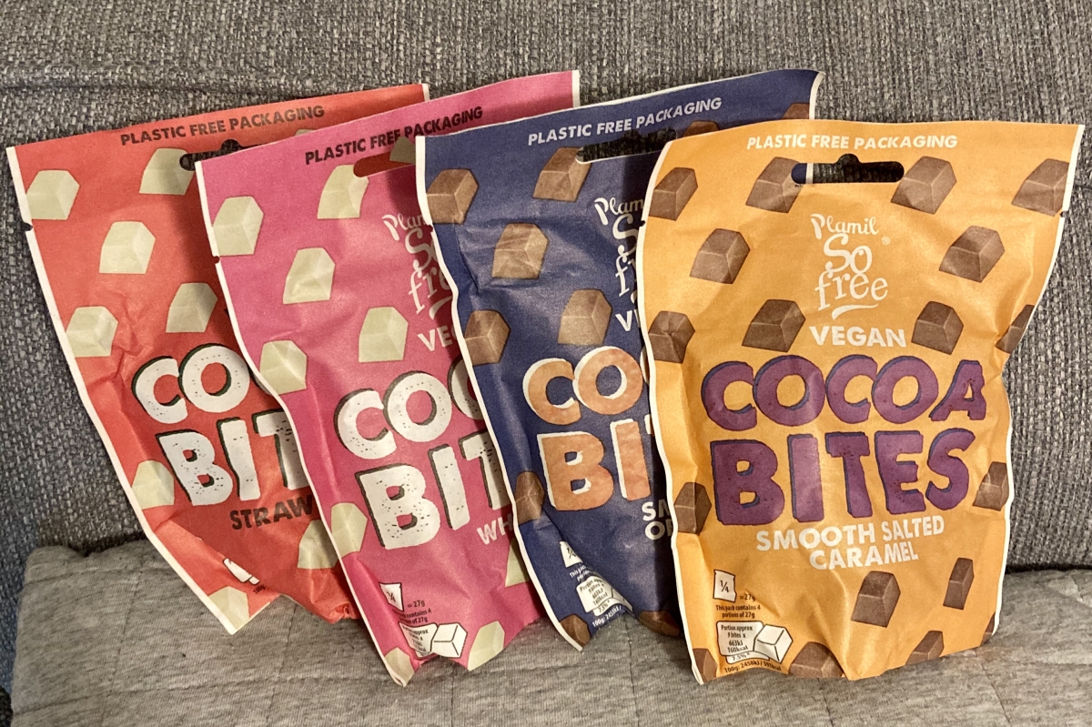 four paper packets of plamil's cocoa bites in various colours, flavours are white, strawberry, chocolate orange and salted caramel