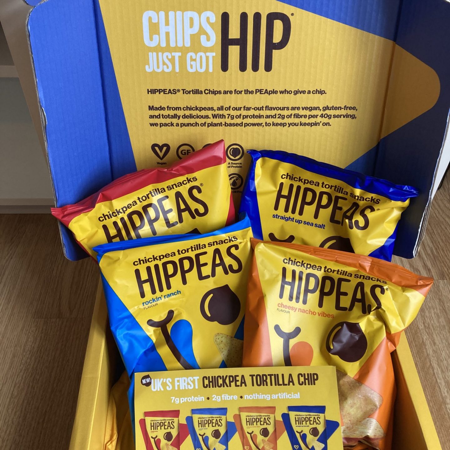 colourful box of hippeas tortilla chips in four different flavours, including yellow promotional leaflets