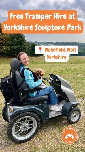 Pippa in a hired Tramper outdoors at Yorkshire Sculpture Park, with her little dog securely in a backpack on her front.