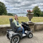 Pippa on a rented Tramper at Trelissick, with beautiful views of nature and the estuary behind her.
