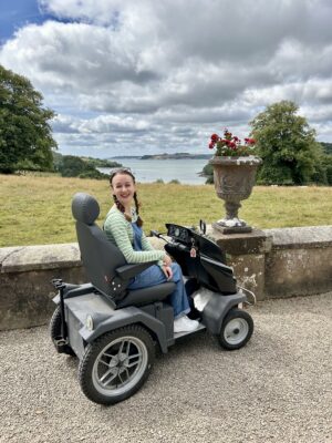 Pippa on a rented Tramper at Trelissick, with beautiful views of nature and the estuary behind her.